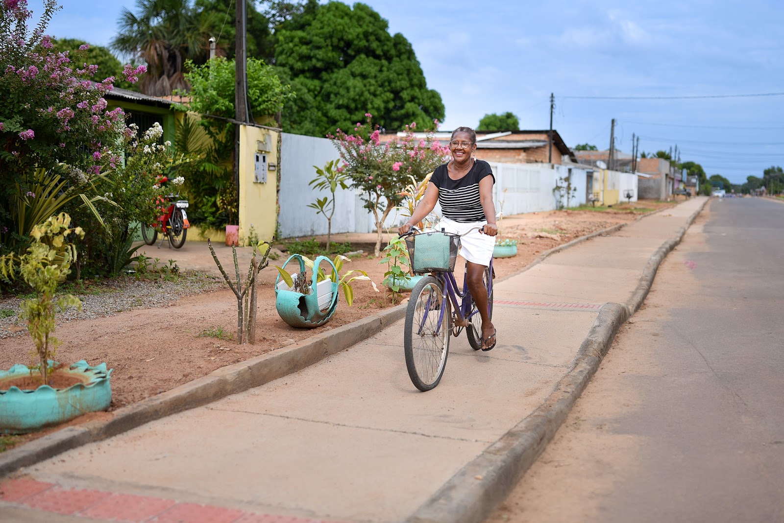 Moradores caminham em nova calçada construída no bairro Bela Vista, melhorando a infraestrutura em Boa Vista.