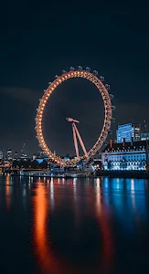 London Eye Illuminated at Night Reflecting on Thames River