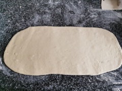 Lấy bột ra khỏi tô khi thấy bột gần gấp đôi lúc đầu. Cán bột mỏng và dài theo hình chữ nhật như hình. Cắt bột hình tam giác rồi tạo hình. Muốn giống hình cua các bạn nên bẻ hai đầu bột cong vào nhé. Bánh mì cua của chúng ta sắp hoàn thành rồi đó.