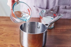 Cho đường trắng và nước lên nồi, vặn lửa vừa và khuấy đều cho đến khi hỗn hợp nóng chảy, đường tan hết, bạn đừng để nước đường sôi nhé, chỉ cần đường tan hết là được.