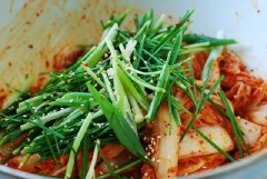 Cải thảo rửa sạch lại với nước, cho vào tô cùng hỗn hợp ở bước 3, hành lá, hẹ, mè trắng, trộn đều.