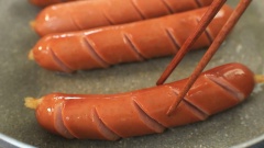 Thoa đều 1 muỗng canh dầu ăn lên chảo, đợi dầu nóng thì đặt từng cây xúc xích vào chiên từ 1 đến 2 phút cho chín vàng đều. Phương pháp chiên sẽ giúp xúc xích có màu vàng óng rất đẹp, những khứa cắt trên xúc xích nở vừa phải, tạo cảm giác đẹp mắt và sự ngon miệng.
