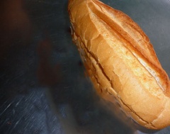 Cắt dọc 1 bên bánh mì, phết đều muối tiêu và tương ớt vào bên trong.