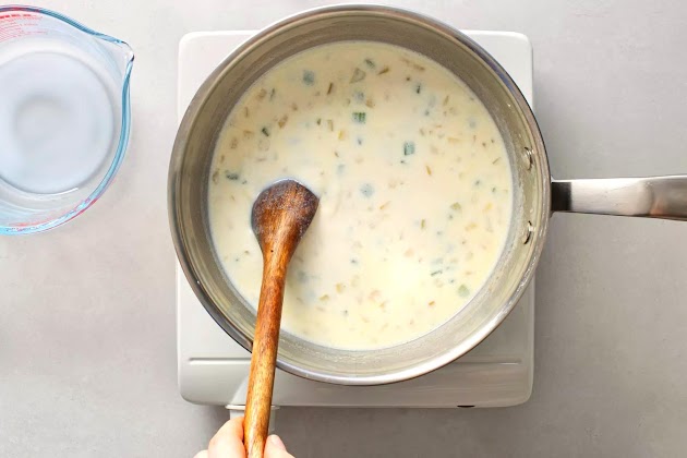Agregue la harina y la leche a la mezcla de cebolla en la cacerola.
