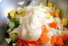 Cắt nhỏ lòng đỏ, lòng trắng trứng cho vào tô. Thêm ruột bánh mì, khoai tây, cà rốt, dưa leo, 2 muỗng canh sốt mayonnaise, 1 muỗng cà phê mù tạt, 1/2 muỗng cà phê tiêu vào tô, trộn đều.
