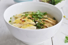 Sau đó, cho thịt gà chặt lên trên tô miến, thêm nước dùng vào, rắc hành lá lên trên là đã hoàn thành rồi đấy!