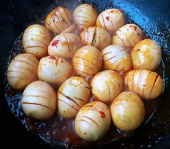 Cho trứng đã lột vỏ vào nồi sốt, lăn đều để sốt thấm hết gia vị và phủ đều khắp trứng. Chế bia vào sao cho ngập mặt trứng. Đun sôi trứng cùng nước sốt trên lửa nhỏ và rim đến khi sốt cạn, trứng đổi màu là được. Khi rim bạn nhớ thỉnh thoảng lật trở trứng để gia vị thấm đều nha. Tắt bếp, gắp trứng ra dĩa rau xà lách, rắc chút mè lên là có thể thưởng thức.