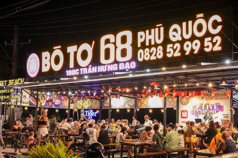 푸꾸옥 Bò tơ 68 매장 야간 전경 — 저녁 시간대에 좌석이 한 번에 차는 상권입니다