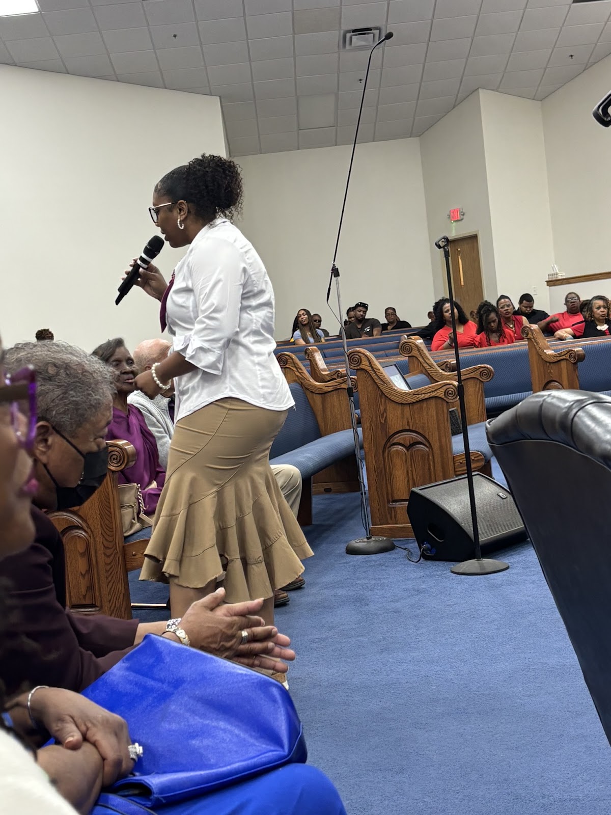 Female vocalist singing in the aisle with congregation watching at Homecoming 2026