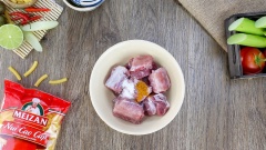Cho 100gr thịt cua đã luộc chín, 100gr giò sống, 2 muỗng cà phê hạt nêm, 1 muỗng cà phê hành tím băm, 1 muỗng cà phê màu điều, 1/3 muỗng cà phê muối, 1/2 muỗng cà phê tiêu, 1 muỗng cà phê nước mắm vào chung một tô sạch. Phết đều cho chả hoà quyện và dai hơn. Trong một tô khác cho sườn heo cùng 1 muỗng cà phê nước mắm, 1 muỗng cà phê bột ngọt, 1/2 muỗng cà phê bột nghệ vào trộn đều, ướp 15 phút cho sườn heo thấm gia vị.