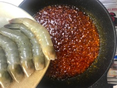 Cho ớt sa tế, 2 muỗng canh đường, 1 muỗng canh nước mắm rồi đảo cho hỗn hợp được trộn đều, cho tôm vào đảo đều cho tôm chín và thấm vị thì tắt bếp.