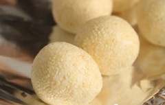Vo đều tay đến khi viên bột tròn đều là được. Đổ mè trắng rang chín ra đĩa rồi lăn từng viên bánh vào cho mè bám đều lên bột.