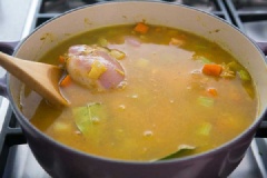 Cho 2 đùi gà vào đảo cùng với hỗn hợp rau củ ở trên. Thêm nước dùng gà, nước vào nồi, nêm muối. Đun đến khi sôi, giảm bớt lửa. Nấu trong 20 phút. Tiếp đến gắp miếng thịt gà ra, kiểm tra gà chín bằng cách dùng que tăm đâm vào miếng thịt, nếu thịt không chảy nước, miếng gà đã chín, còn nếu ngược lại gà chưa chín bạn cho gà trở lại vào nồi, nấu đến khi gà chín.