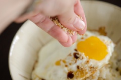 Chuẩn bị phần cơm trắng, để miếng bơ lạt lên trên và úp trứng lên mặt. Độ nóng của trứng chiên sẽ làm tan bơ, lúc này bạn cho nước tương, dầu mè và mè rang vàng vào nhé.
