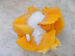 Trước tiên, lá gelatine cần ngâm vào nước đá lạnh 15 phút. Sau đó vớt ra bát, chưng cách thủy rồi chia làm 2 phần bằng nhau để làm 2 lớp panna cotta. Đường và xoài cho vào máy sinh tố xay nhuyễn.