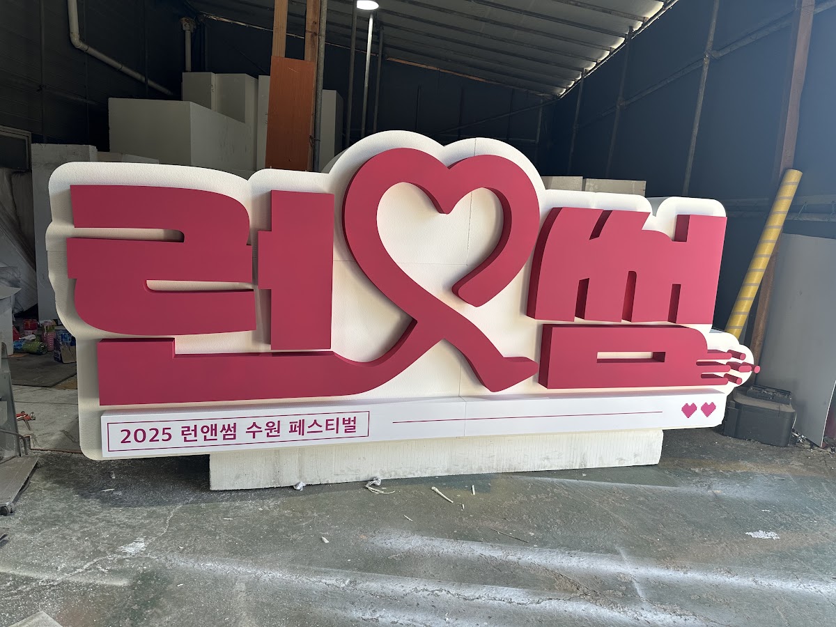전시회 부스 조형물 제작 후 철수한 입체 글자 조형물을 실내 작업장에 세워 보관하는 모습, 재사용을 위한 분할 피스 관리 사례