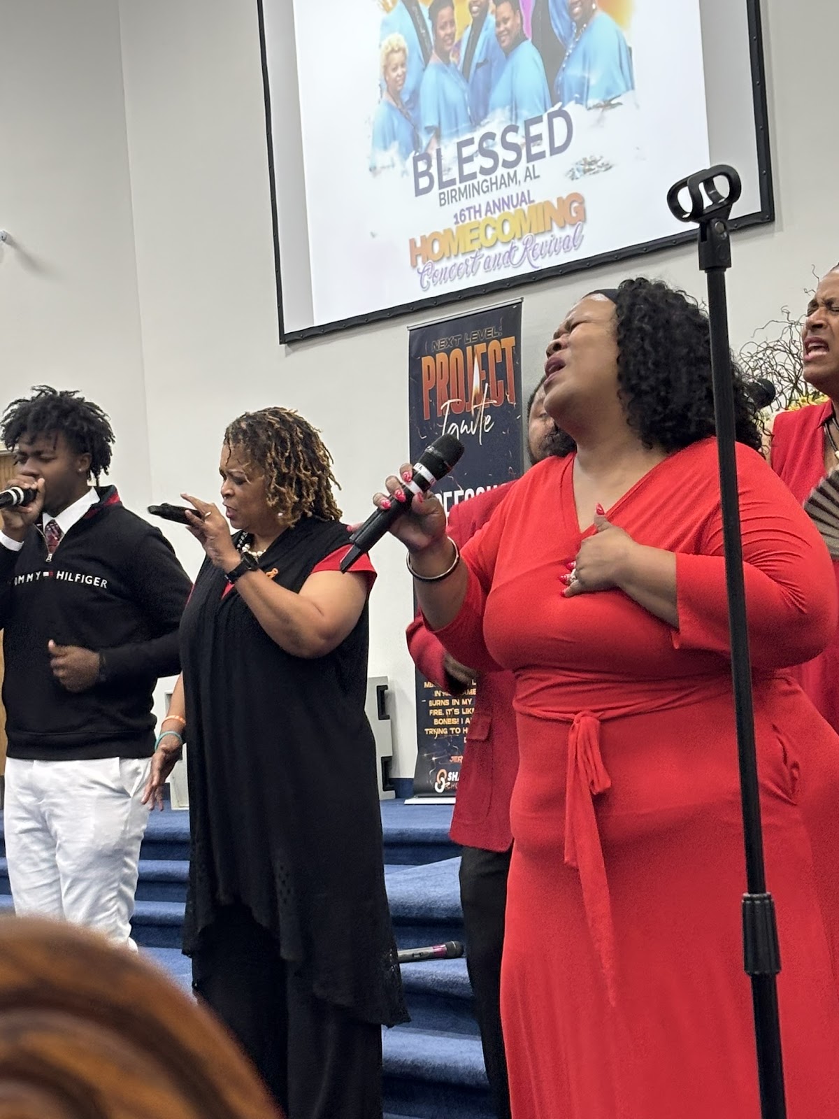 Multiple singers performing with BLESSED Homecoming banner on church screen at Sharpe Road 2026