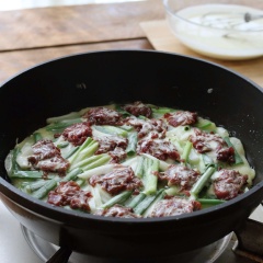 Đun nóng dầu ăn trong chảo, đổ hỗn hợp bột vào chảo (giữa lại 2 muỗng canh bột). Dàn đều bột sau đó xếp đều thịt bò lên trên, chiên một lúc cho bột săn lại. Tiếp đến rưới 2 muỗng canh bột lên thịt, chiên tiếp với lửa nhỏ. Khi thịt bò chín thì đánh tan trứng gà rưới đều lên trên. Rải lên ít ớt, chiên cho trứng chín thì tắt bếp.