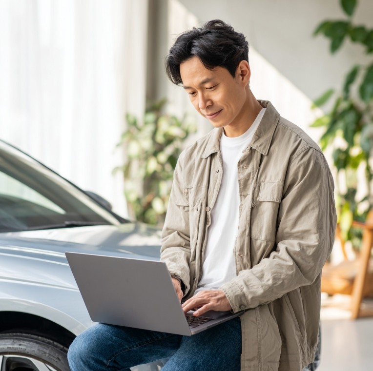 노트북으로 자동차 검사 예약하는 한국인