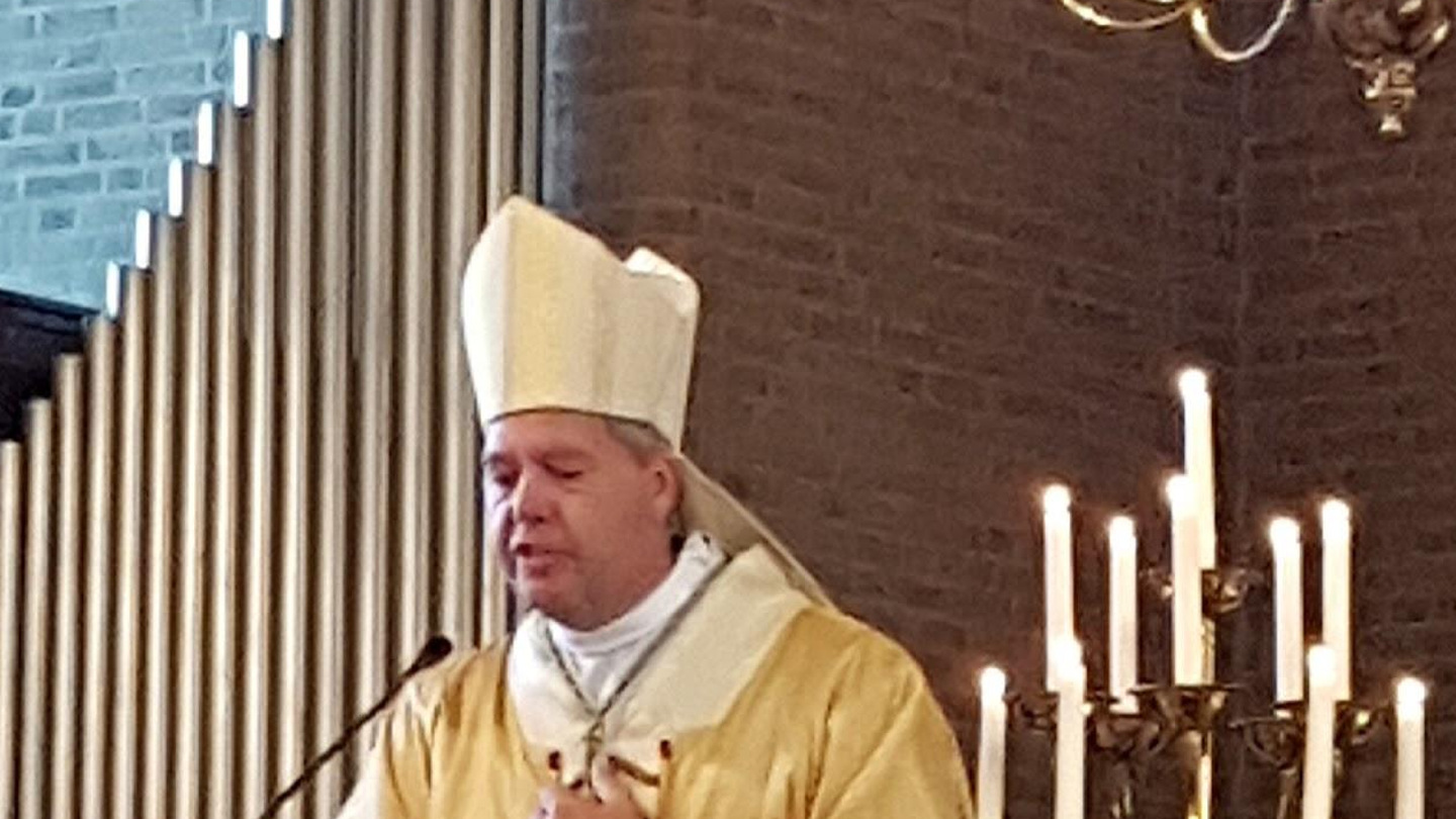 Dom Rob Mutsaerts com mitra e vestes episcopais em igreja católica.