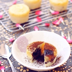 Lấy bánh ra, rắc bột cacao lên trên và dùng ngay. Khi cắt đôi bánh sẽ thấy nhân bên trong chocolate đen tan chảy ra.