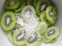 Kiwi rửa sạch, gọt vỏ. Ngâm kiwi trong nước muối pha loãng, sau đó vớt ra để ráo nước. Thái kiwi thành miếng mỏng. Cho kiwi vào bát, thêm đường vào trộn đều rồi ướp đến khi kiwi ngấm đường.