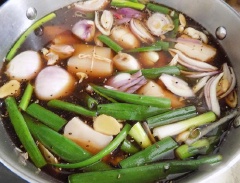 Hành lá cắt khúc. Gừng cắt lát. Hành tím chẻ nhỏ. Tỏi đập dập. Nước cho vào nồi cùng các gia vị, gói trà và hành, tỏi, gừng và hành lá khuấy đều, bắc lên bếp nấu lửa vừa.