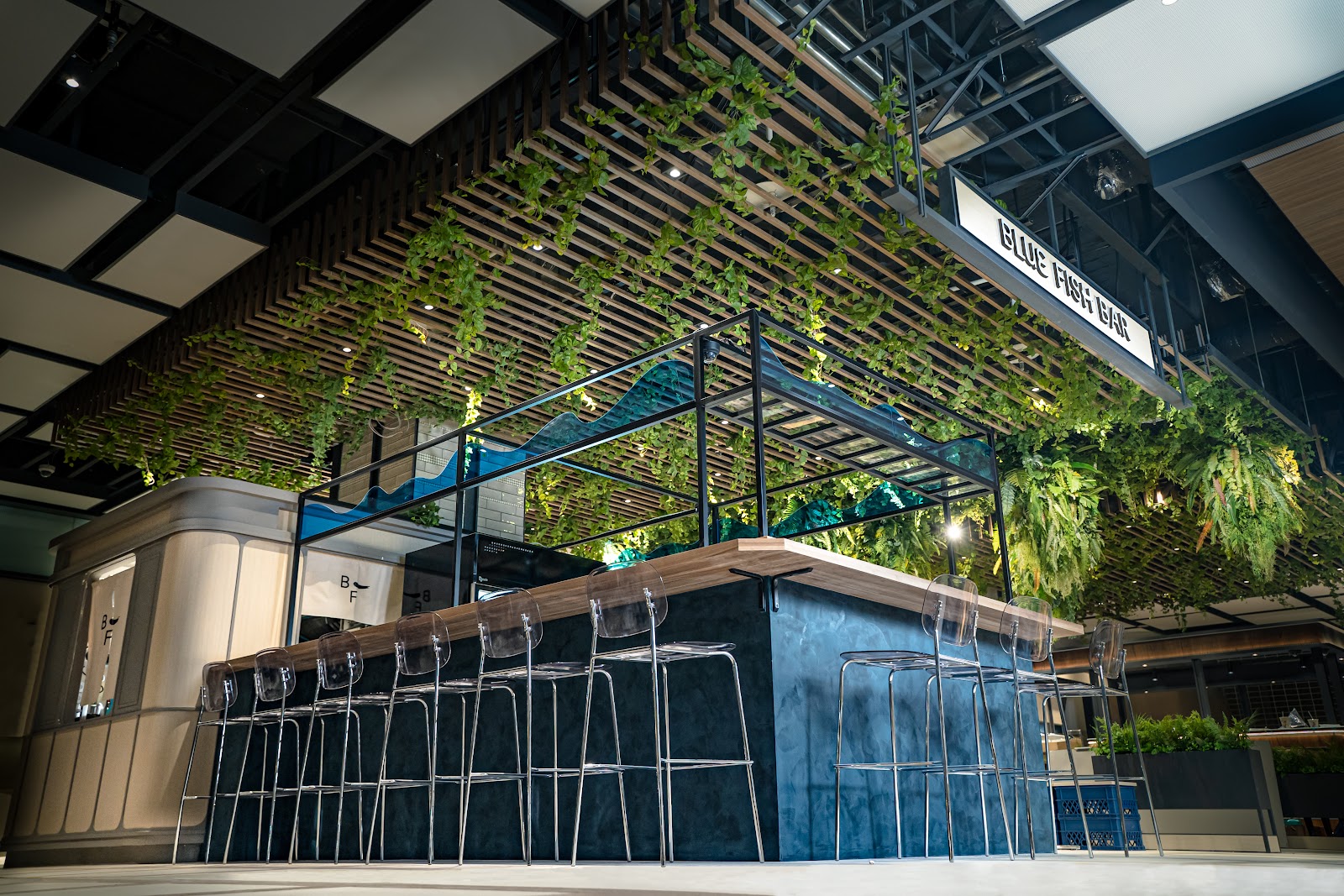 樂魚忠泰空間拍攝，呈現 BLUE FISH BAR 吧台、座位、天花植栽與室內材質
