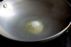 Làm nóng dầu ăn, cho 1 muỗng canh đường còn lại vào. Đợi đến khi dầu sôi, đường chuyển sang vào nâu thì trút thịt vào.