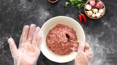 Dùng bao tay nặn thịt thành những viên tròn, nhớ thoa dầu ăn chống dính để nặn thịt được dễ dàng hơn.