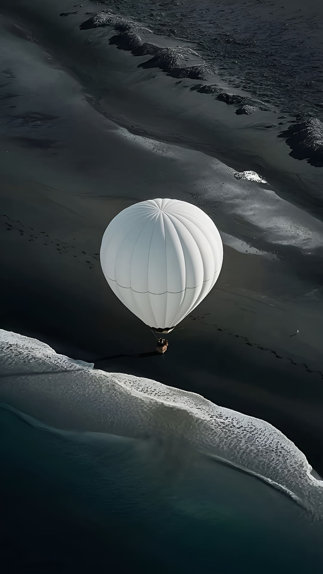 White Hot Air Balloon Flying Over Dark Volcanic Beach - Free 4K mobile Wallpaper