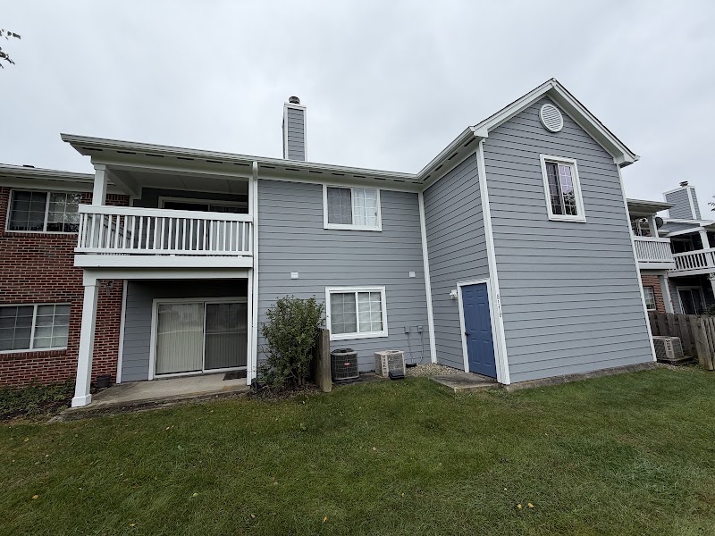 The same rear elevation after the repaint, gray siding and white trim
