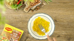 Lấy 50gr bí đỏ đem luộc chín, sau đó cho ra tô nghiền nhuyễn min. Thêm 150gr thịt băm, 5gr đầu hành trắng băm, 5gr hành tím băm, 1 muỗng canh hạt nêm, 1/2 muỗng canh nước mắm, 1/2 muỗng canh đường, 1/2 muỗng cà phê tiêu xay 15 phút cho thấm gia vị. Tôm lột vỏ bỏ đầu chừa đuôi, rút bỏ chỉ lưng, lấy 100gr tôm đem cắt hạt lựu. Cho tôm hạt lựu vào trong, bọc thịt băm bên ngoài tạo thành những viên thịt nhỏ vừa ăn.