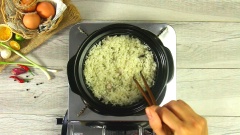 Vo sạch gạo, để ráo. Cho chút dầu ăn vào nồi, phi thơm hành tím băm, cho gạo vào rang đều cho dậy mùi. Sau đó mới bắt đầu nấu chín cơm bằng nước luộc gà và mỡ gà để lấy màu vàng tự nhiên nhất.
