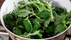 Đun nóng 1 muỗng canh dầu ăn, cho vào nồi 1 muỗng canh hành tím băm và 1/2 muỗng canh gừng băm phi vàng thơm. Tiếp theo cho 200gr lá ngải cứu vào xào sơ.