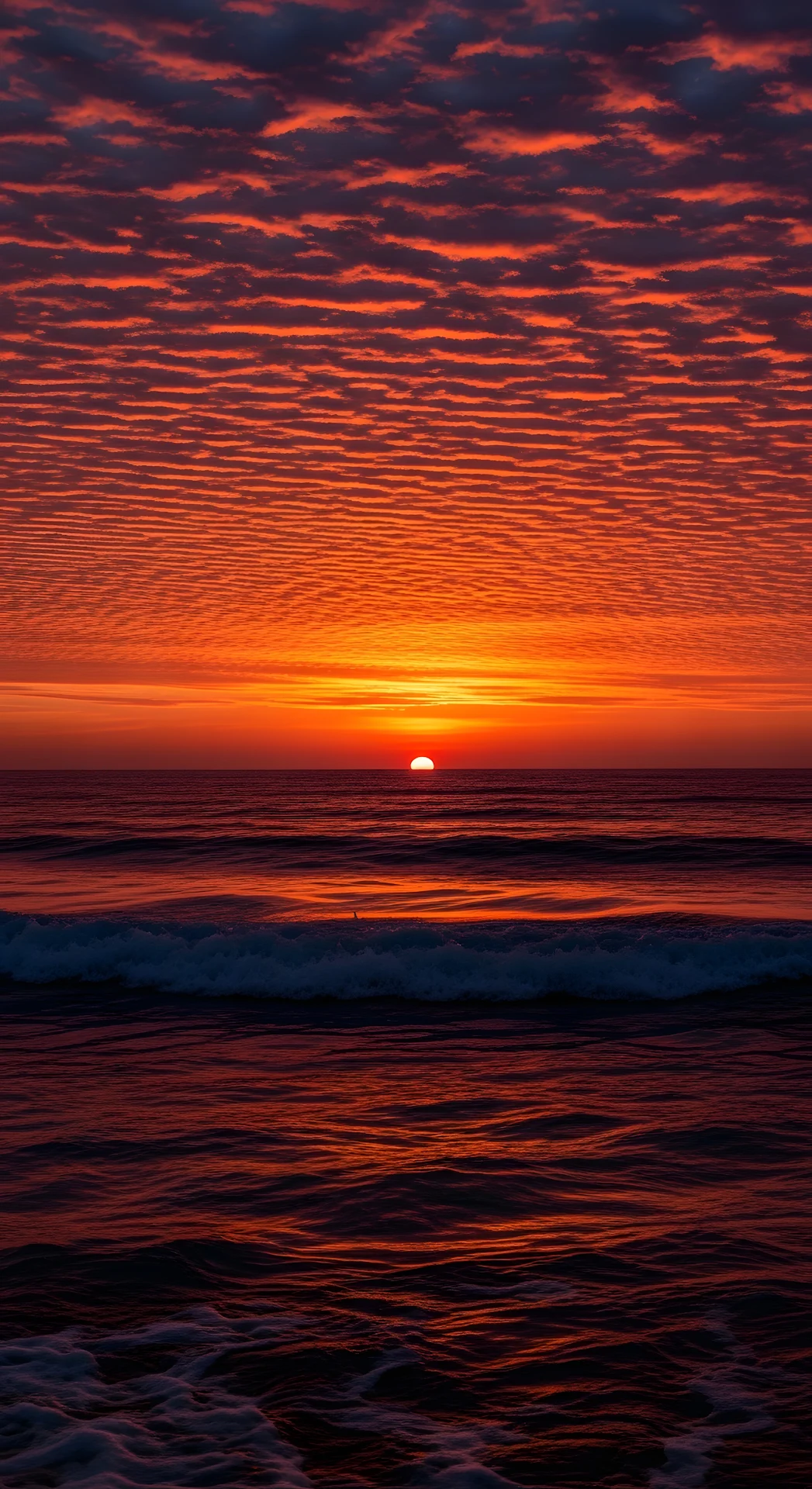 Dramatic Red and Orange Ocean Sunset with Textured Clouds and Rippling Water - Free 4K mobile Wallpaper