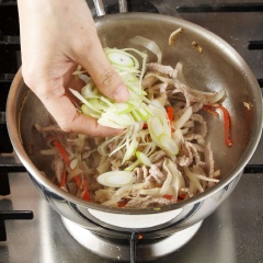Đun nóng 1 muỗng canh dầu ô liu, cho rễ cây ngưu bàng vào xào 1-2 phút. Cho thịt bò vào xào cho thịt bò săn lại. Thêm tiếp hành tây, ớt xào xào cho dịu lại. Nêm chén nước sốt vừa pha xào 1 phút cho ngâm gia vị. Cuối cùng cho hành lá vào, đảo đều tắt bếp.