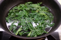 Lá húng quế rửa sạch, để ráo. Chế nước vào nồi, nấu sôi rồi thả lá húng quế vào trụng tầm 10 giây thì vớt ra cho ngay vào tô nước lạnh rồi lấy ra, để ráo nước. Tiếp đó, cho lá húng quế, hạt thông, dầu olive, tỏi, 1/2 muỗng cà phê muối và 30g phô mai Parmesan vào máy sinh tố. Bật nút, xay thật nhuyễn mịn hỗn hợp là xong rồi đó.