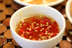 Hòa tan 2 muỗng canh nước mắm, 1 muỗng canh giấm, 1 muỗng canh đường trắng, ớt cắt nhỏ vào chén, khuấy đều. Đậu phộng rang chín, giã hơi nhỏ.