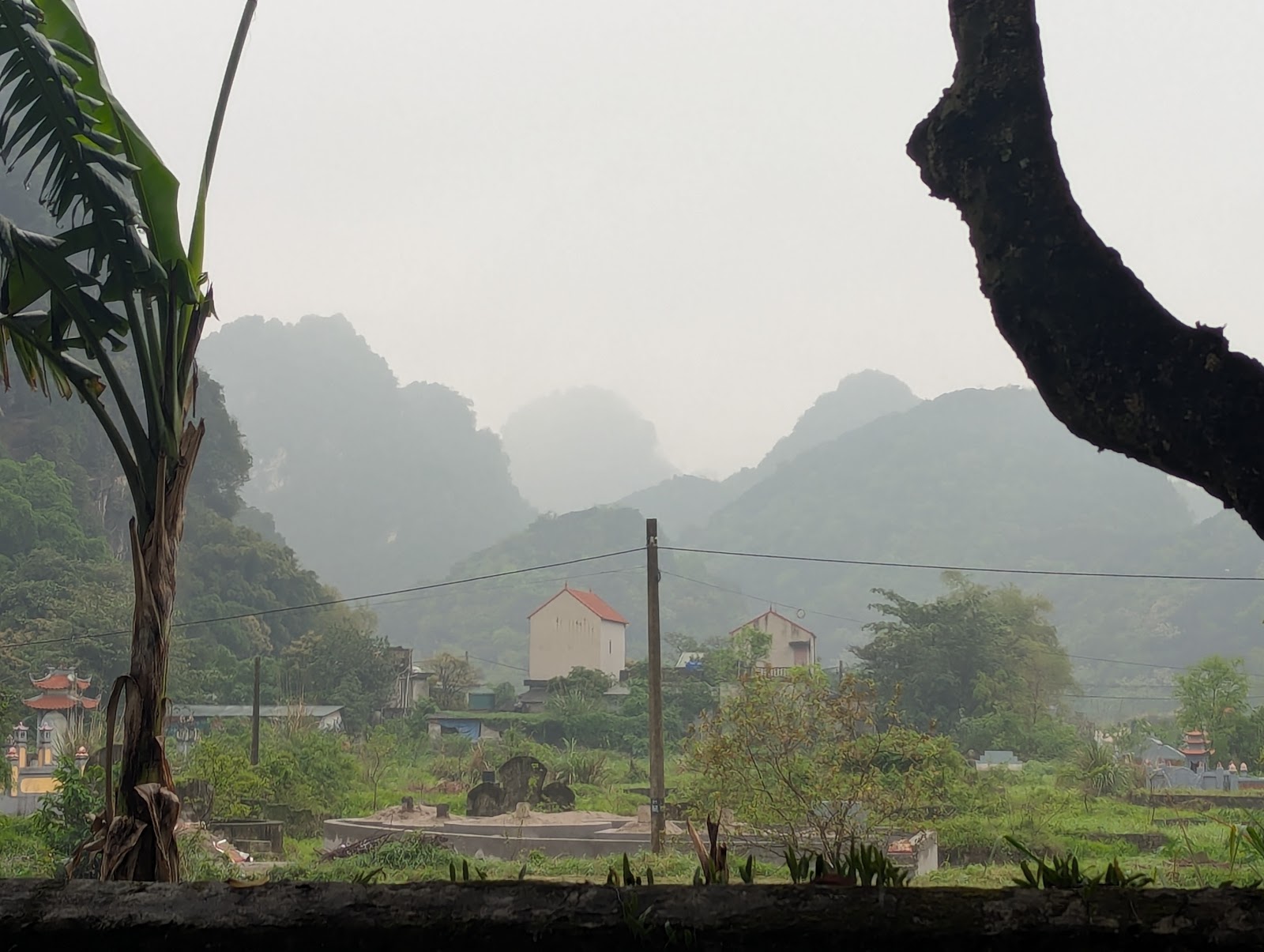 A photo looking over a retaining wall at some green mountains.