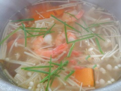 Xào thơm hành boa rô với 1 muỗng canh dầu ăn, thêm 1 lít nước vào đun sôi với lửa lớn. Sau đó, cho bí đỏ vào, nêm 1 muỗng canh hạt nêm, 1 muỗng cà phê nước mắm, 1 muỗng cà phê đường, 1/2 muỗng cà phê muối. Khi bí chín thì cho nấm kim châm vào, đun thêm 3-4 phút thì tắt bếp.