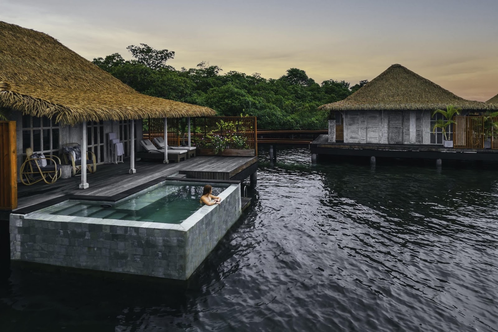 Overwater villas at Nayara Bocas del Toro in Panama, surrounded by tropical greenery and calm Caribbean water.