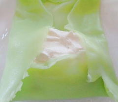 Cách làm bánh crepe nhân kem sầu riêng: Trải miếng vỏ bánh crepe ra, cho kem whipping, hỗn hợp nhân sầu riêng vào. Tiếp theo là thêm 1 lớp kem whipping nữa, gấp đều các mép bánh crepe lại thật chặt tay.