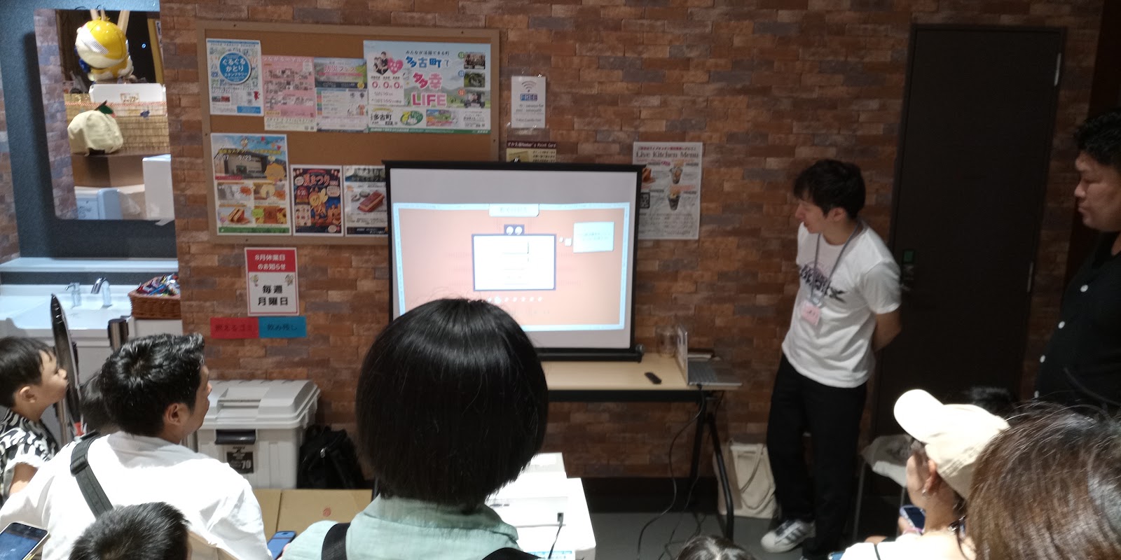 AIお絵かきゲームの画面を見ながら楽しむ参加者