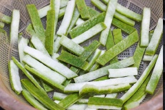 Đổ vỏ bưởi ra rổ, rửa lại nhiều lần với nước cho hết phèn chua, bóp nhẹ vỏ bưởi cho hết nước. Đổ vỏ bưởi vào âu to, thêm đường vào trộn đều ngâm trong khoảng 5 tiếng để đường ngấm vào vỏ bưởi.
