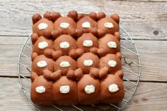 Sau khi bánh chín, lấy bánh ra khỏi khuôn, để lên rack chờ bánh nguội hẳn, nung chảy chocolate trắng, dùng muỗng thoa lên chính giữa làm mũi gấu. Tiếp tục nung chảy chocolate đen, cho vào túi bắt bông kem, cắt 1 lỗ thật nhỏ, vẽ hai mắt và lỗ mũi gấu như hình. Chờ chocolate khô hẳn là có thể dùng. Nếu dùng không hết có thể cho vào hộp đậy nắp kín để bánh không bị khô.