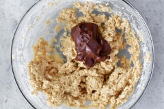 Cắt nhỏ chocolate rồi đun chảy bằng cách đun cách thủy hoặc cho vào lò vi sóng khoảng 30 giây, trộn đều để chocolate cho tan hoàn toàn. Cho chocolate đã đun chảy vào hỗn hợp bột, đánh cho hoàn quyện.