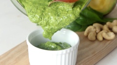 Cải bó xôi rửa sạch, cho khoảng 60gr cải bó xôi cùng 30gr hạt điều đã rang, 50gr bơ sáp và 2 viên đá viên vào máy xay rồi xay mịn. Sau đó cho vào 50ml đầu olive, 1 chút muối và tiêu, xay mịn hỗn hợp một lần nữa, vậy là sốt pesto chay đã hoàn thành.