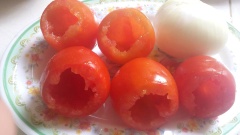 Tiến hành nhồi thịt: Cho thịt heo vào trái cà chua đã nạo sạch ruột, nhồi thịt đến ngang miệng trái. Làm tương tự đến hết thịt và cà chua.