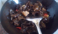 Sau đó cho nấm mèo vào, nêm vào 1/2 muỗng cà phê muối, 1/4 muỗng cà phê đường, 1/2 muỗng canh nước tương và 1 muỗng canh dầu hào. Xào cho nấm quyện đều gia vị thì rắc thêm hành lá, tắt bếp.